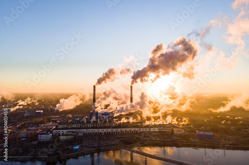 Industrial zone with a large chimney pipe thick white smoke is poured from the factory pipe in contrast to the sun. Pollution of the environment: smokestack with smoke. Aerial view