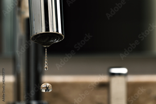 Gota de água caindo da torneira photo