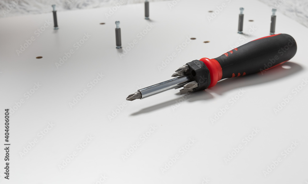 screwdriver on a light board in front of the screws. Furniture assembly tool
screwdriver on a light board in front of the screws. Furniture assembly tool