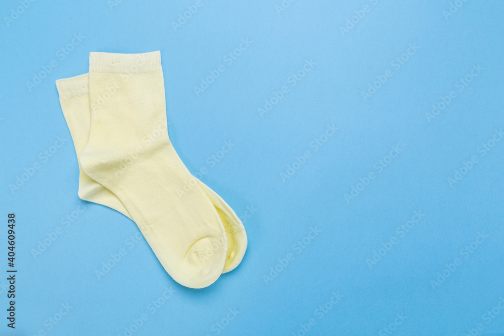 yellow new socks stacked on a blue background. top view. place for text. yellow new socks stacked on a blue background. top view. place for text.