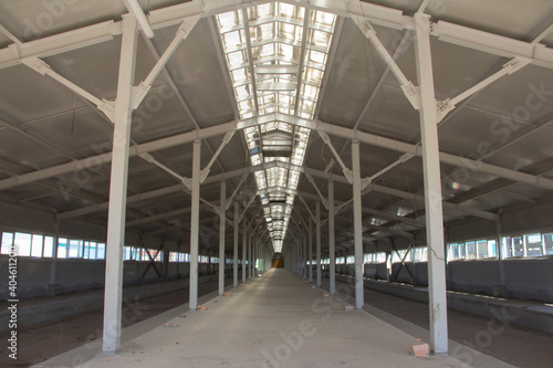 Inside the production building under construction. Metal frame of the building with a sandwich panel of insulation on the wall. Engineering solutions in modern building construction © Vasiliy Ulyanov