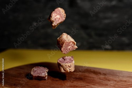 homemade sausage on a wooden board on a gray-yellow background