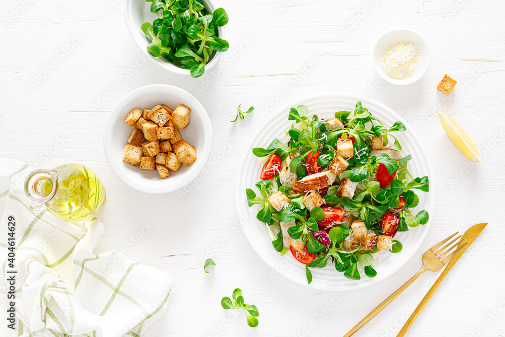 Fotografie Caesar salad with grilled chicken meat, fresh tomato, croutons, lambs lettuce and parmesan cheese