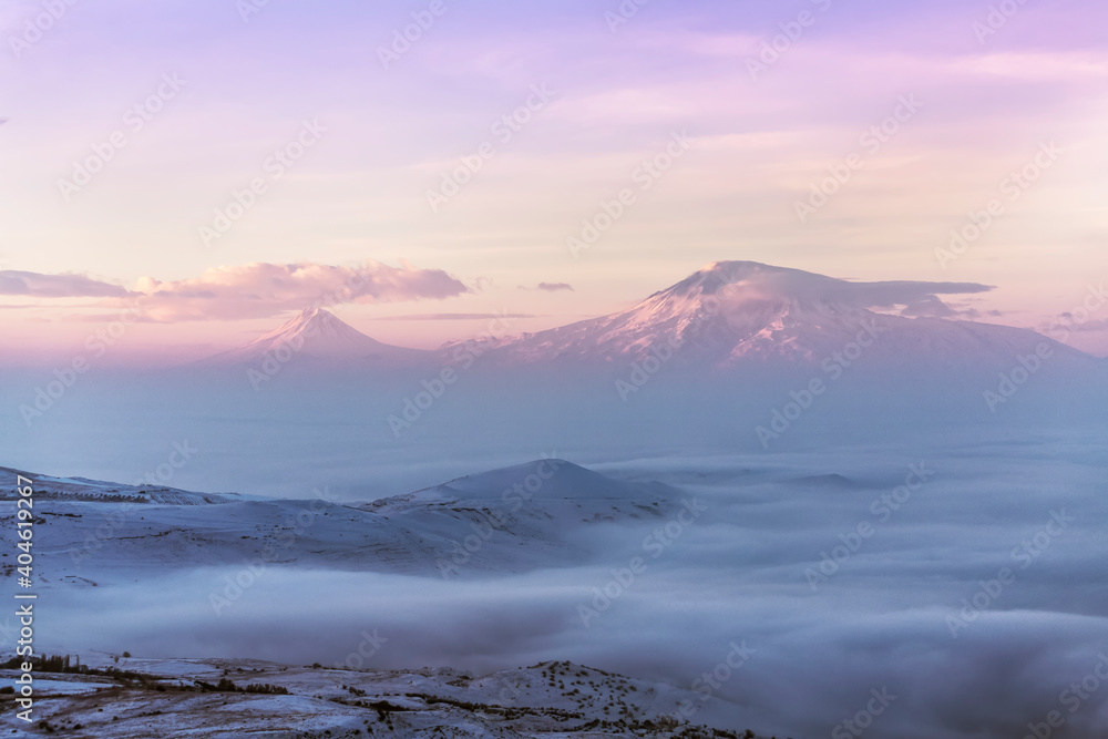 Beautiful sunrise with long exposure clouds. The mountains in a clouds and fog. Ararat mountain.