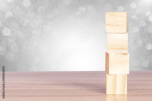 Fototapeta Naklejka Na Ścianę i Meble -  Wooden blocks stack on the table with a bokeh background. Abstract geometric real floating wooden cube.