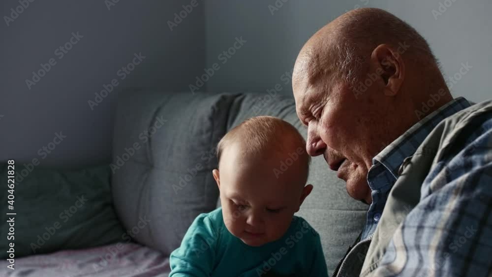 Close up portrait of great granfather sitting on sofa and playing with grandson. Close up portrait of great granfather sitting on sofa and playing with grandson.