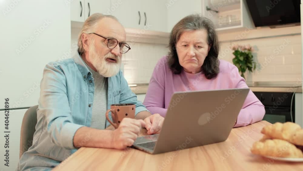 Sad pensioners looking at laptop, discussing utility bills, financial problem Sad pensioners looking at laptop, discussing utility bills, financial problem