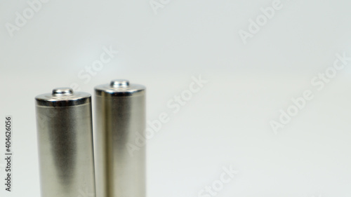 AA alkaline rechargeable batteries on white glossy background with reflection. Close up two empty batteries with copy space.
