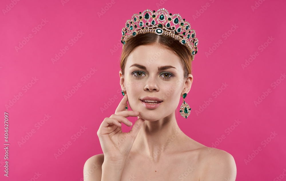 Charming lady with a crown on her head naked shoulders earrings make-up model Charming lady with a crown on her head naked shoulders earrings make-up model