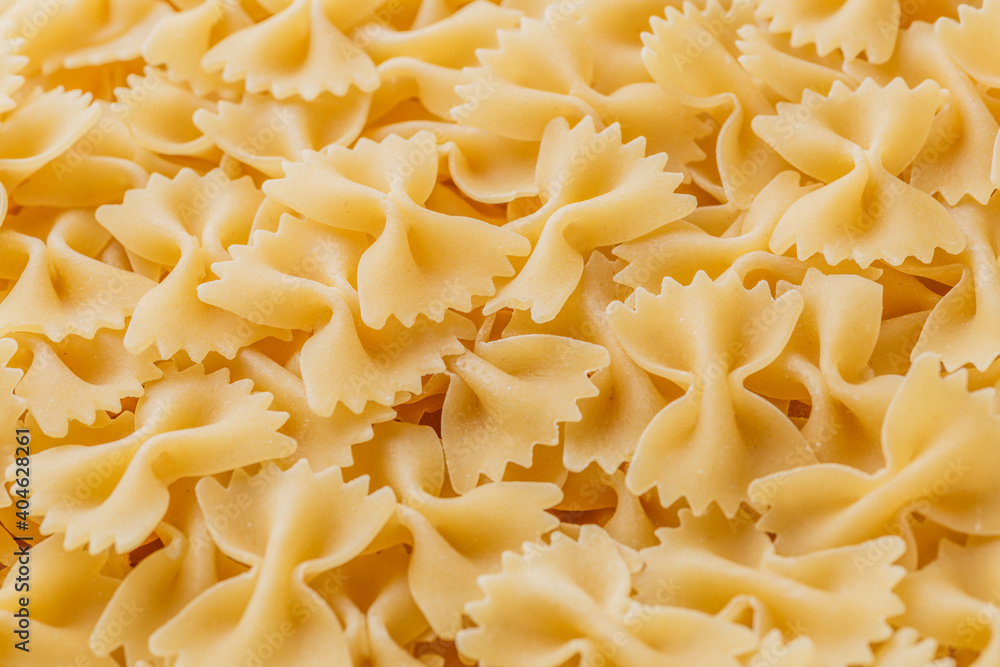Traditional Italian farfalle pasta. Italian Cuisine. Bow tie noodles. Uncooked dried farfalle. Butterfly. Top view. Traditional Italian farfalle pasta. Italian Cuisine. Bow tie noodles. Uncooked dried farfalle. Butterfly. Top view.