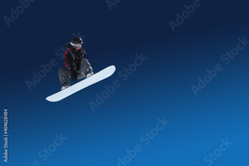 Snowboarder female athlete extreme jump flight isolated on blue gradient. Designer stub