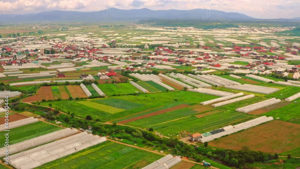 drone flies above rural area above view on farm with greenhouse agricultural field in summer season drone flies above rural area above view on farm with greenhouse agricultural field in summer season