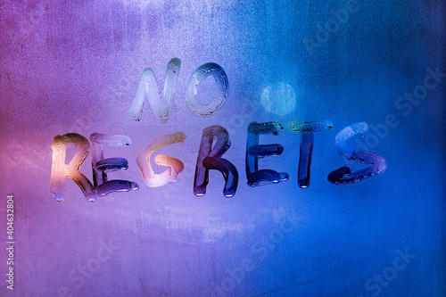 words no regrets hand written on purple-blue night foggy window glass photo