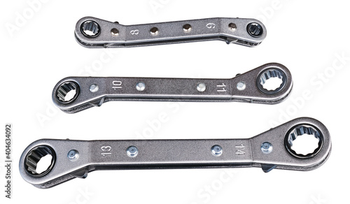 Set of ratcheting box-end wrenches or ring spanners isolated on white background. Close-up of double head ratchet handles. Three various sized metal hand tools for screwing and tightening nut or bolt. photo