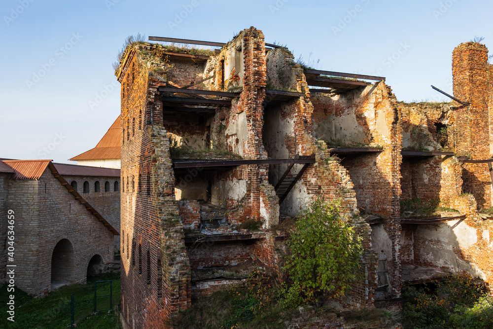 An old ruined building, without windows or doors, made of red bricks. The destroyed walls of the house An old ruined building, without windows or doors, made of red bricks. The destroyed walls of the house