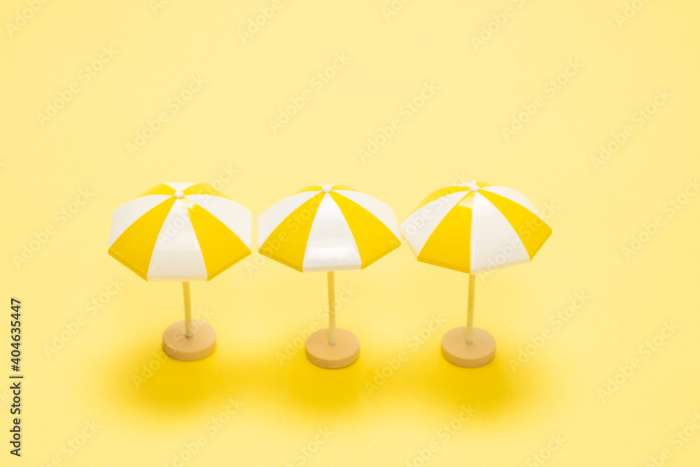 Sun lounger and yellow umbrella on a yellow background.