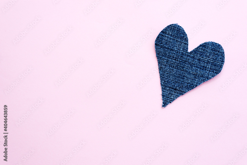 Blue denim heart on light pink background. Valentine card with copy space.