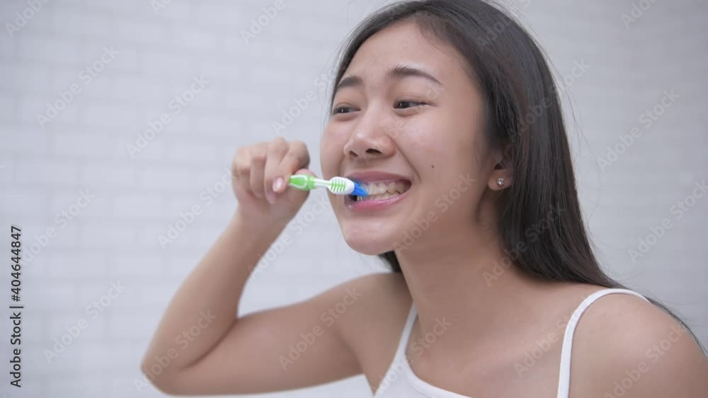 Daily routine concept of 4k Resolution. Asian woman brushing teeth in the bathroom. Daily routine concept of 4k Resolution. Asian woman brushing teeth in the bathroom.