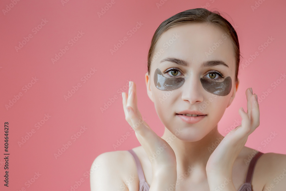 Head shot portrait close up smiling young woman with under eye moisturizing patches mask looking at camera enjoying skincare procedure Head shot portrait close up smiling young woman with under eye moisturizing patches mask looking at camera enjoying skincare procedure