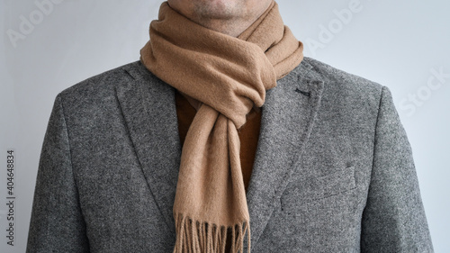 Detail of mens outfit, fashionable grey tweed blazer combined with light beige scarf.  Selective focus. photo