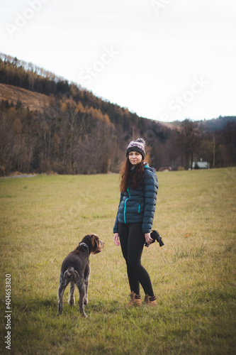 gorgeous smiling woman is on a walk with her dog Bohemian Wire-haired Pointing Griffon. The domestic dog listens to his mistress. The relationship between man and hunting dog. Devotion to the Lord