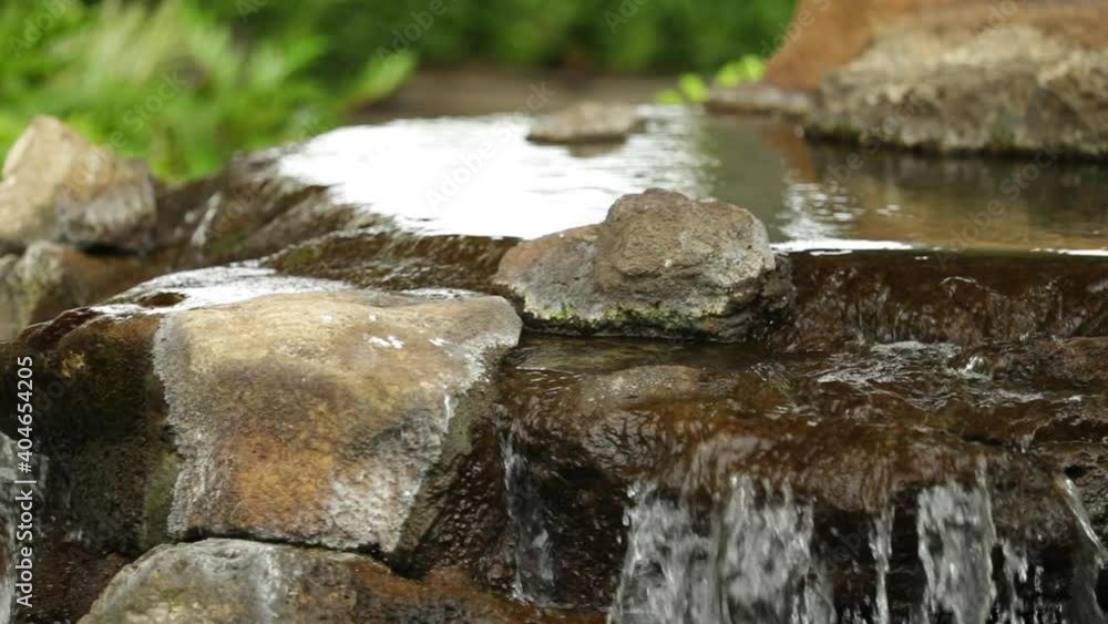 Slow motion - Small waterfall close-up of water running over rocks Slow motion - Small waterfall close-up of water running over rocks