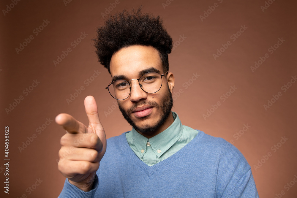 Young contemporary mixed-race businessman in eyeglasses pointing at you Young contemporary mixed-race businessman in eyeglasses pointing at you