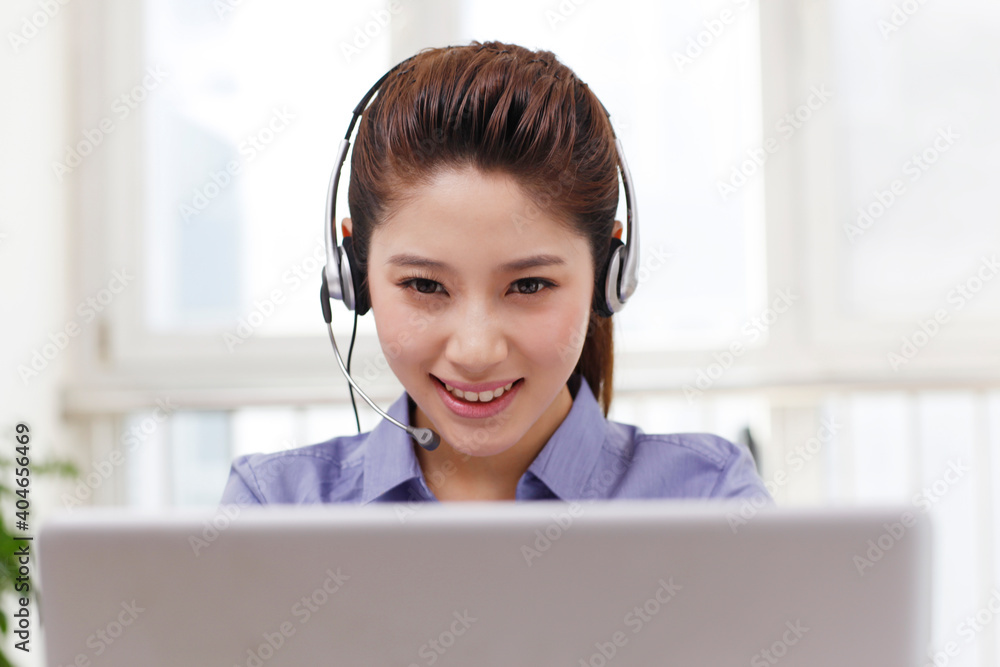 Business woman with headset using a laptop Business woman with headset using a laptop