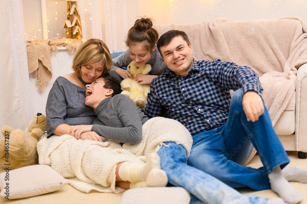 portrait of a family sitting on a sofa at home, four people having fun together portrait of a family sitting on a sofa at home, four people having fun together