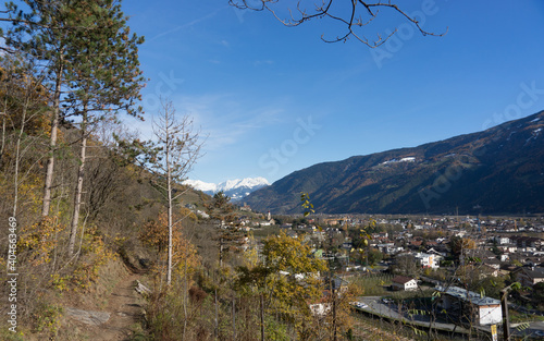 Picturesque mountain landscape in South Tyrol in autumn, view from a hiking trail nearby a vineyard to the valley of Naturns, in the background the snow-covered Alps, no people