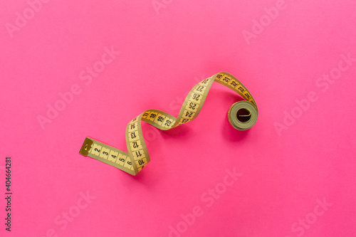 Measure tape on pink background. Diet and weight loss concept.. Flat lay, top view, copy space