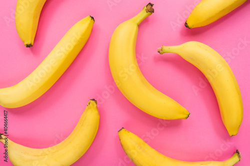 Colorful fruit pattern of fresh yellow bananas on pink background. Fruit concept. Flat lay, top view