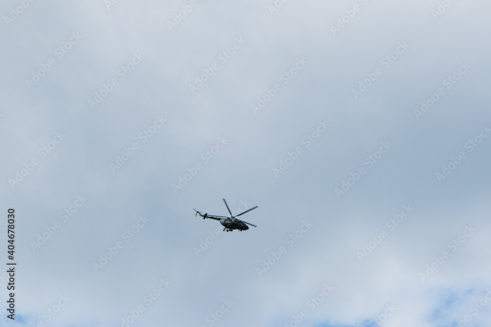 helicopter on a background of blue sky with clouds helicopter on a background of blue sky with clouds