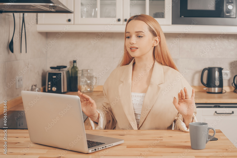 Woman behind laptop works from home. A beautiful blonde in a jacket speaks by video call. The student submits a report online. The girl teaches courses, lectures on the Internet. Freelance earnings. Woman behind laptop works from home. A beautiful blonde in a jacket speaks by video call. The student submits a report online. The girl teaches courses, lectures on the Internet. Freelance earnings.
