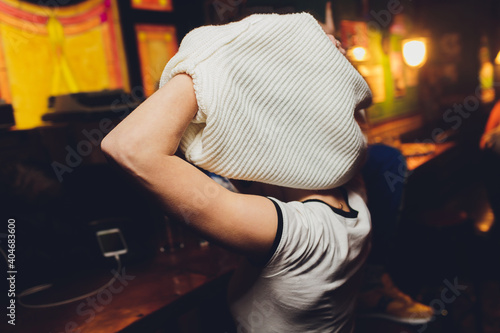 Funny girl takes off a white stylish sweater.