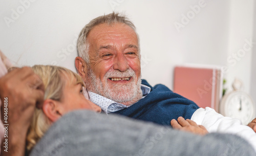 Senior happy couple relaxing and talking together lying on bed in bedroom at home.Retirement couple concept