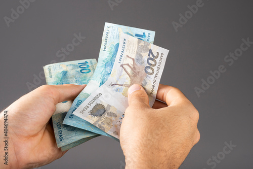 Hand of a man holding Brazilian notes Reais