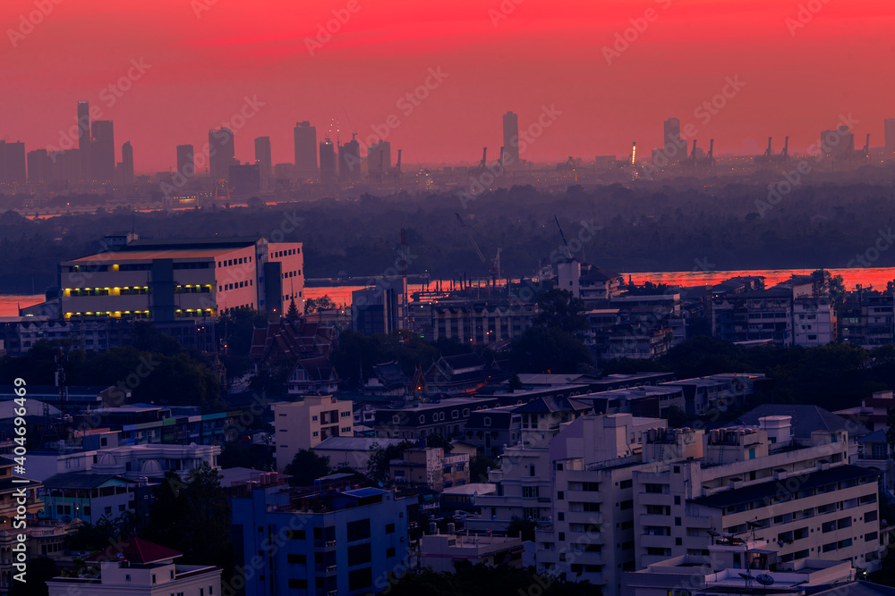 Fototapeta premium The high angle background of the city view with the secret light of the evening, blurring of night lights, showing the distribution of condominiums, dense homes in the capital community