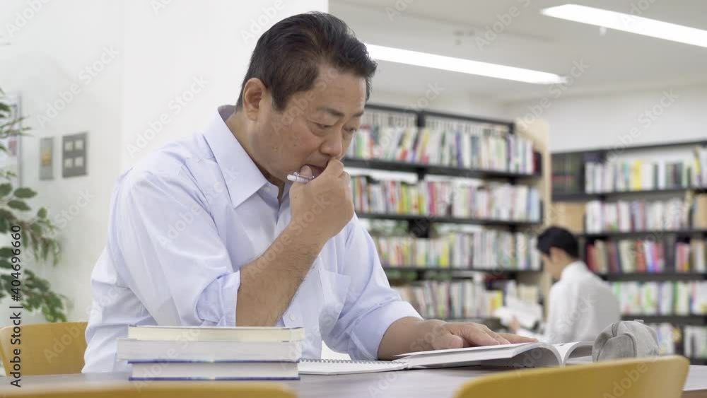 図書館で勉強する中年男性 図書館で勉強する中年男性