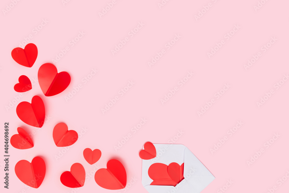 Red hearts from envelop background, paper cut romantic concept, top view. Beautiful cute hearts on pastel pink table flat lay composition. Valentines, Mothers Day anniversary design. 