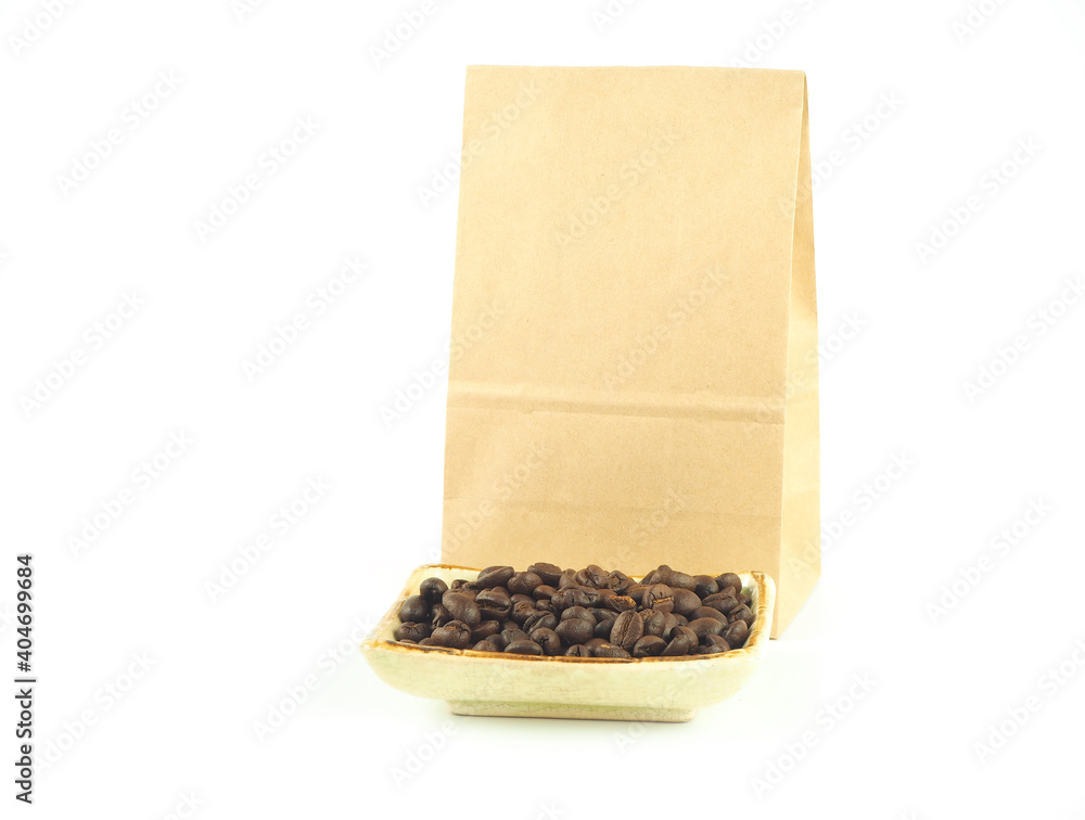 Brown kraft paper bag with coffee beans in plate isolated on a white background.. Brown kraft paper bag with coffee beans in plate isolated on a white background..