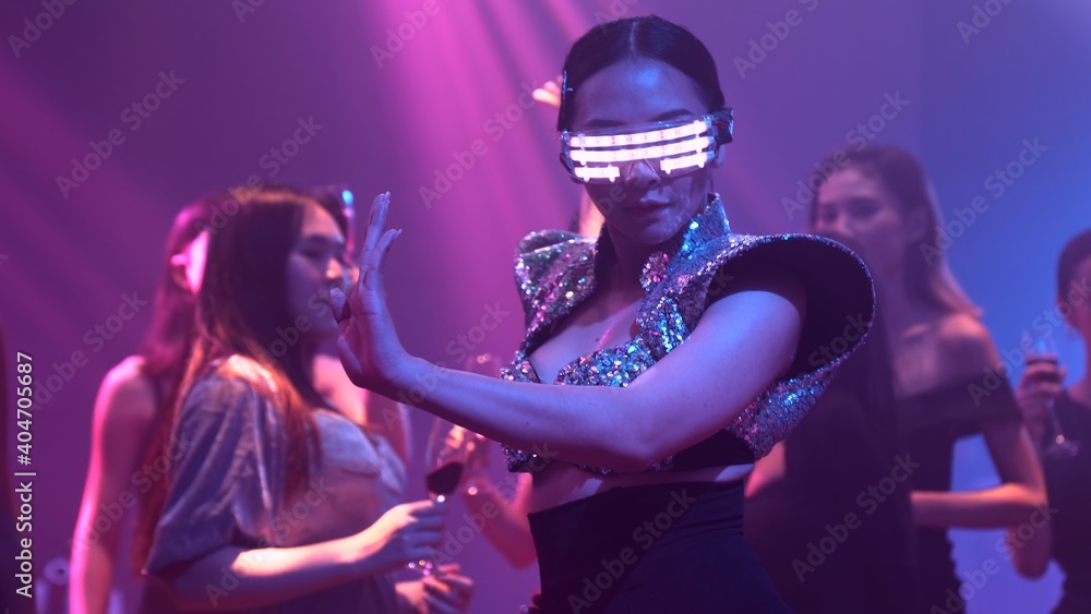 Group of people dance in disco night club to the beat of music from DJ on stage . New year night party and nightlife concept . - obrazy, fototapety, plakaty 