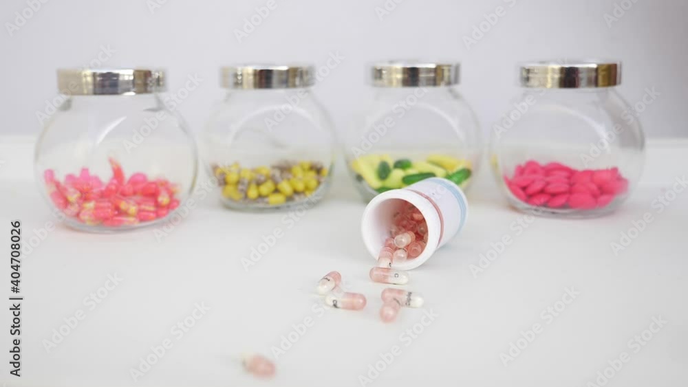 Shot of dropping bottle filled with capsule on a table Shot of dropping bottle filled with capsule on a table