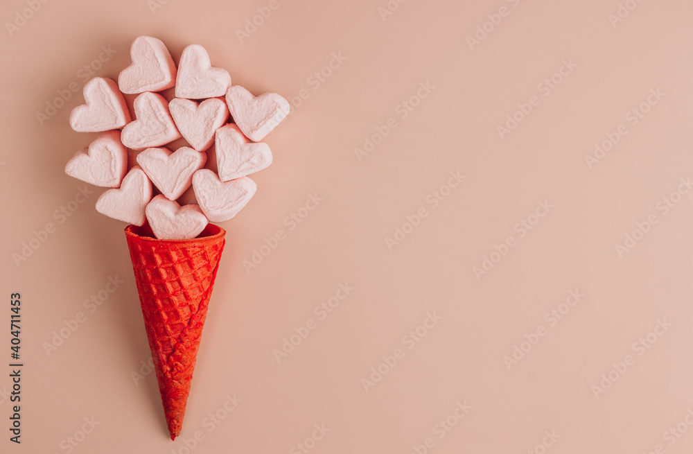 Pink and white heart shaped marshmallows with waffle cone on pink background. Pink and white heart shaped marshmallows with waffle cone on pink background.