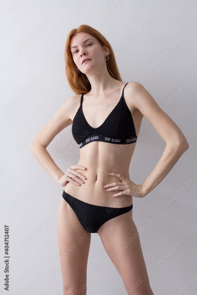 snap shot of pretty model in black lingerie on white background with red hair snap shot of pretty model in black lingerie on white background with red hair