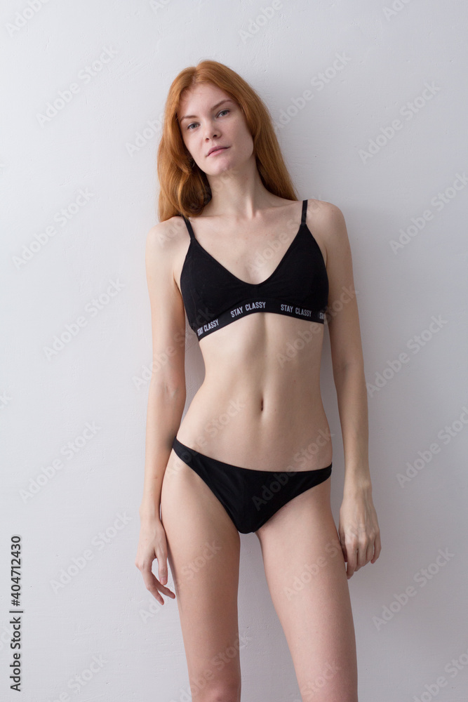 snap shot of pretty model in black lingerie on white background with red hair snap shot of pretty model in black lingerie on white background with red hair