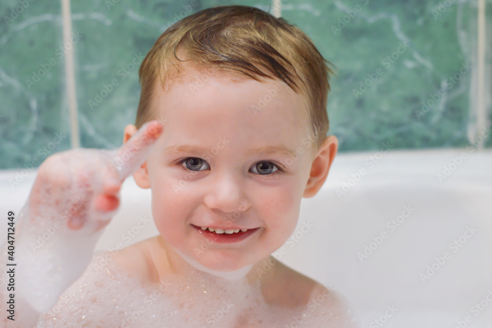 A little boy is bathing in a bubble bath. Portrait of a happy child