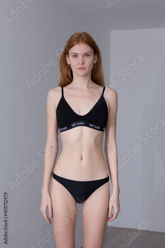 snap shot of pretty model in black lingerie on white background with red hair	