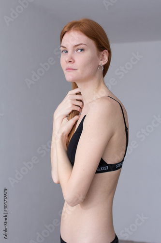 snap shot of pretty model in black lingerie on white background with red hair 