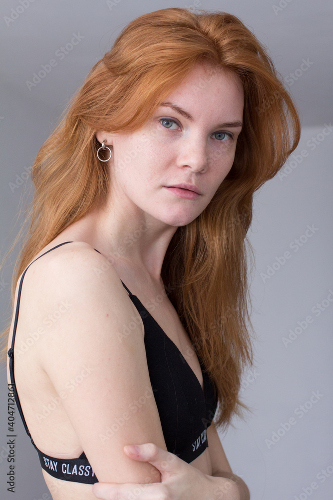 Naklejka premium snap shot of pretty model in black lingerie on white background with red hair 